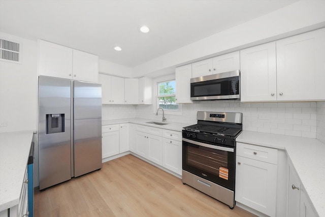 163 Queenswood Rd, Bolingbrook, IL 60440 - kitchen featuring stainless steel appliances, a sink, recessed lighting, light wood-style floors, and white cabinets