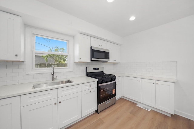 163 Queenswood Rd, Bolingbrook, IL 60440 - kitchen featuring stainless steel appliances, a sink, light wood-type flooring, white cabinetry, and recessed lighting