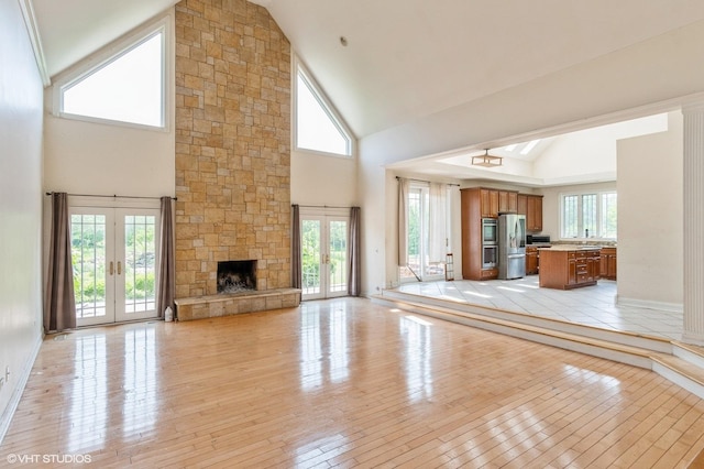 4722 Douglas Rd, Oswego, IL 60543 - unfurnished living room with french doors, high vaulted ceiling, light wood finished floors, and a stone fireplace