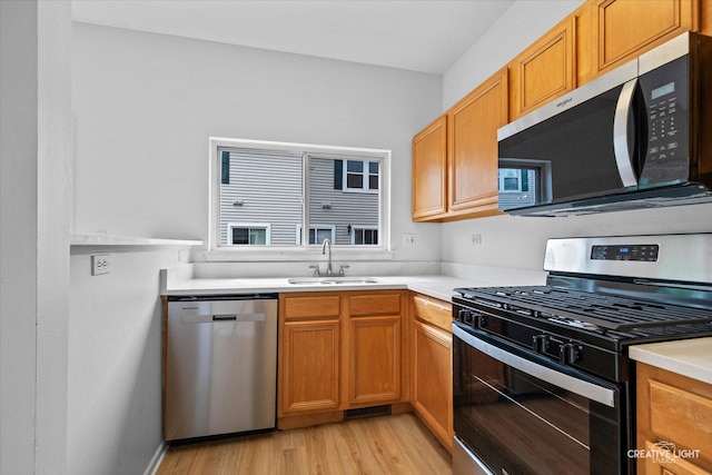 1096 Village Center Pkwy Unit 6, Aurora, IL 60506 - kitchen with stainless steel appliances, a sink, light wood-style flooring, light countertops, and brown cabinetry