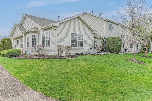 303 Capitol Dr Unit A, Sugar Grove, IL 60554 - view of property exterior featuring a lawn and roof with shingles
