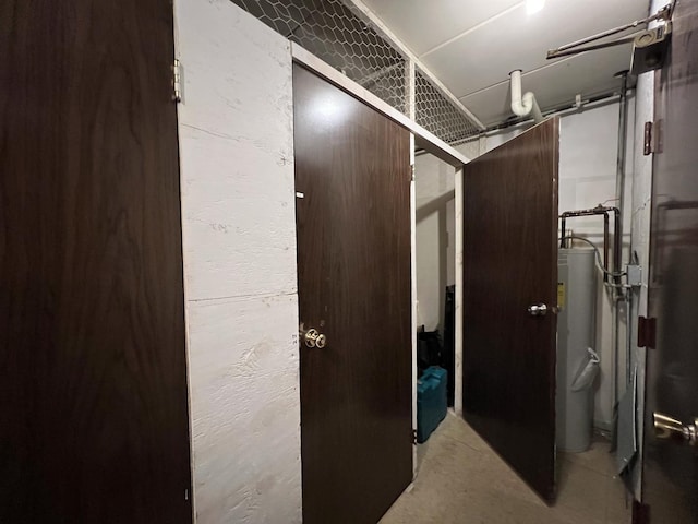 603 S River Rd Unit 2K, Des Plaines, IL 60016 - corridor with unfinished concrete floors, water heater, and a textured wall