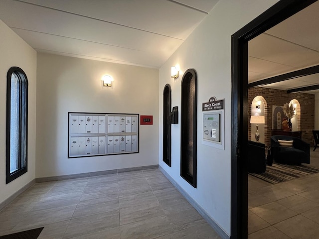 603 S River Rd Unit 2K, Des Plaines, IL 60016 - hallway with mail area, tile patterned flooring, and baseboards