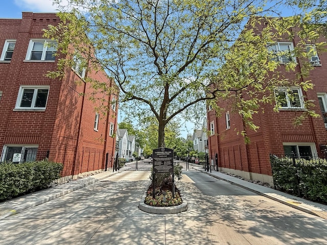 2847 N Wolcott Ave Unit D, Chicago, IL 60657 - view of concrete road featuring a gate, curbs, a residential view, and a gated entry