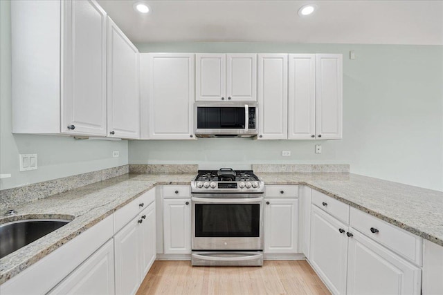 2847 N Wolcott Ave Unit D, Chicago, IL 60657 - kitchen with appliances with stainless steel finishes, white cabinetry, light wood-style flooring, and recessed lighting