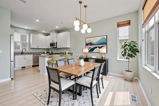 2847 N Wolcott Ave Unit D, Chicago, IL 60657 - dining area with light wood-style flooring, baseboards, recessed lighting, and a chandelier