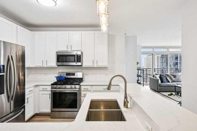 1111 S Wabash Ave Unit 1410, Chicago, IL 60605 - kitchen featuring stainless steel appliances, a sink, light stone counters, and tasteful backsplash