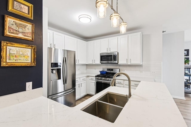 1111 S Wabash Ave Unit 1410, Chicago, IL 60605 - kitchen with stainless steel appliances, a sink, light wood-style flooring, light stone counters, and white cabinetry