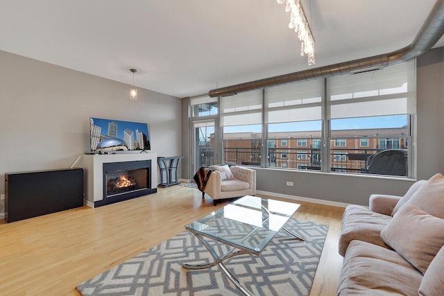 1200 W Monroe St Unit 514, Chicago, IL 60607 - living area with wood finished floors, a warm lit fireplace, and baseboards