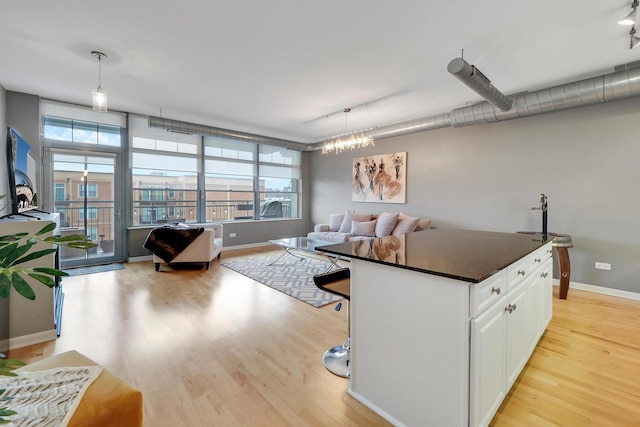 1200 W Monroe St Unit 514, Chicago, IL 60607 - living room with light wood finished floors, track lighting, baseboards, and a chandelier