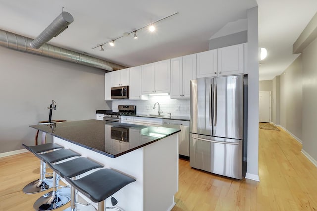 1200 W Monroe St Unit 514, Chicago, IL 60607 - kitchen with stainless steel appliances, a sink, rail lighting, light wood-style flooring, and white cabinetry
