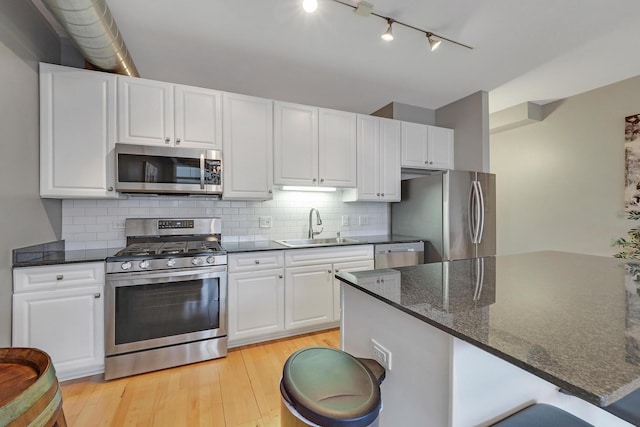 1200 W Monroe St Unit 514, Chicago, IL 60607 - kitchen featuring appliances with stainless steel finishes, a sink, track lighting, light wood-style flooring, and white cabinets