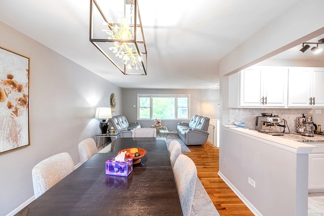 8106 W 89th Pl, Hickory Hills, IL 60457 - dining room featuring light wood-style floors, a chandelier, and baseboards