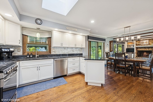 3S180 Cypress Dr, Glen Ellyn, IL 60137 - kitchen featuring appliances with stainless steel finishes, a sink, a peninsula, ornamental molding, and white cabinets