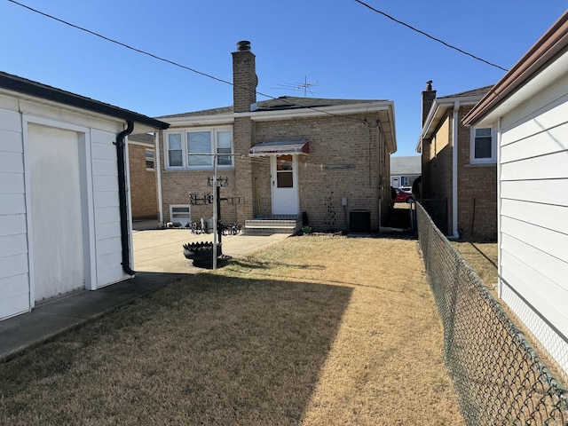 7711 Massasoit Ave, Burbank, IL 60459 - back of property featuring brick siding, a chimney, and central AC