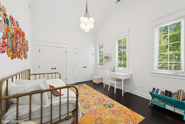 1959 W Berwyn Ave, Chicago, IL 60640 - bedroom featuring multiple windows, multiple closets, dark wood-style flooring, a chandelier, and high vaulted ceiling