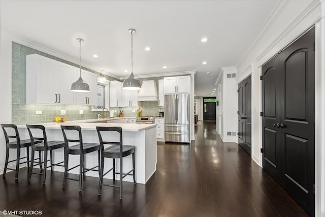 1959 W Berwyn Ave, Chicago, IL 60640 - kitchen featuring appliances with stainless steel finishes, premium range hood, a peninsula, light countertops, and ornamental molding