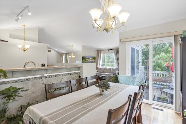 2439 Daybreak Ct Unit 2439, Elgin, IL 60123 - dining space featuring a chandelier, rail lighting, lofted ceiling, and wood finished floors