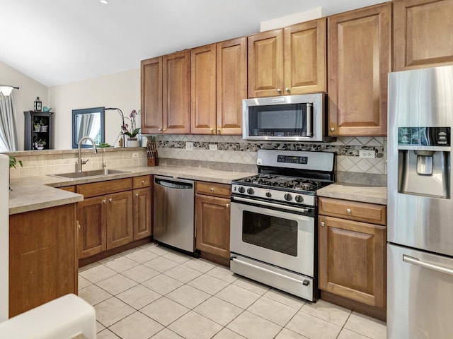 2439 Daybreak Ct Unit 2439, Elgin, IL 60123 - kitchen with appliances with stainless steel finishes, a sink, backsplash, light tile patterned floors, and vaulted ceiling