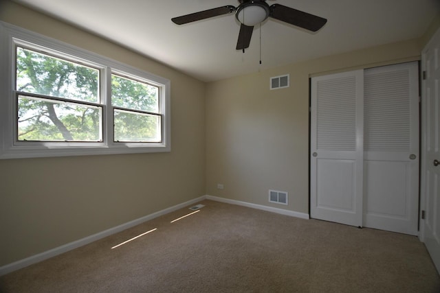 unfurnished bedroom with carpet floors, a closet, and a ceiling fan