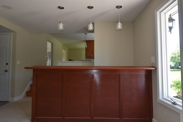 bar area featuring hanging light fixtures and carpet