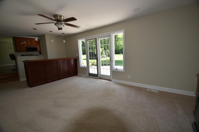 unfurnished living room with ceiling fan and light colored carpet