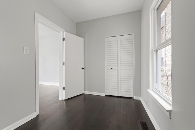 5123 W 23rd Pl, Cicero, IL 60804 - unfurnished bedroom featuring multiple windows, dark wood-type flooring, and baseboards
