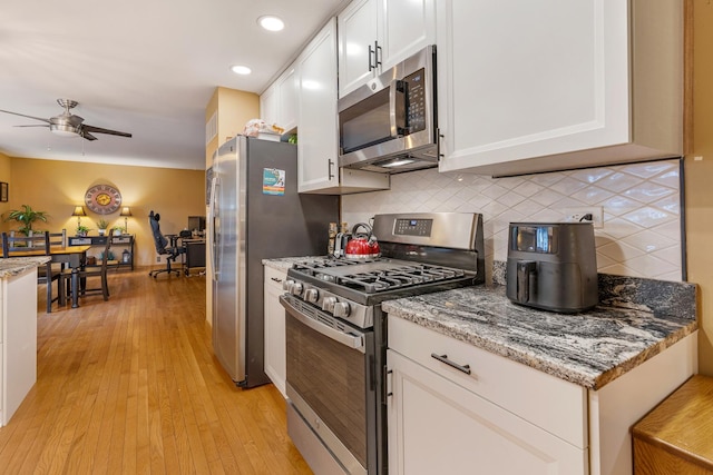 67 Alice St, Algonquin, IL 60102 - kitchen with appliances with stainless steel finishes, a ceiling fan, white cabinetry, decorative backsplash, and light wood finished floors