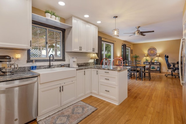 67 Alice St, Algonquin, IL 60102 - kitchen featuring stainless steel dishwasher, a sink, a peninsula, a ceiling fan, and white cabinetry
