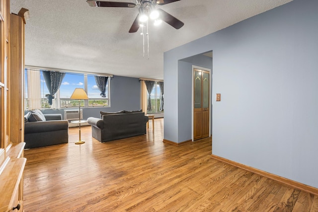 8815 W Golf Rd Unit 7A, Niles, IL 60714 - living room featuring light wood-type flooring, ceiling fan, baseboards, and a textured ceiling