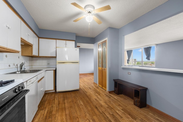 8815 W Golf Rd Unit 7A, Niles, IL 60714 - kitchen with white appliances, a sink, a textured ceiling, white cabinets, and wood finished floors