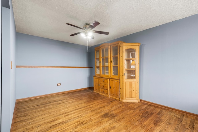 8815 W Golf Rd Unit 7A, Niles, IL 60714 - unfurnished room featuring wood finished floors, a ceiling fan, a textured ceiling, and baseboards