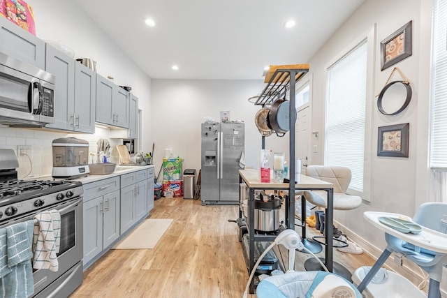 3331 S Ashland Ave, Chicago, IL 60608 - kitchen featuring stainless steel appliances, gray cabinetry, light wood-type flooring, decorative backsplash, and recessed lighting