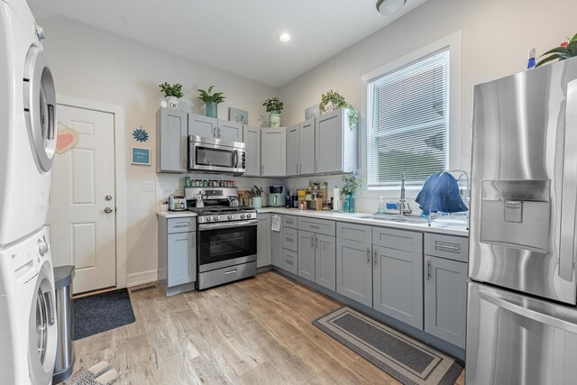 3331 S Ashland Ave, Chicago, IL 60608 - kitchen featuring stainless steel appliances, estacked washer and dryer, gray cabinets, a sink, and light countertops