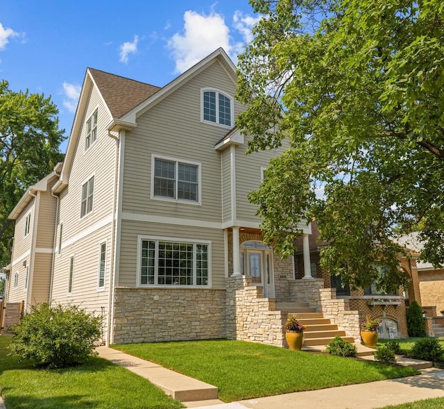 6972 W Imlay St, Chicago, IL 60631 - view of front of house featuring stone siding, a front yard, and roof with shingles
