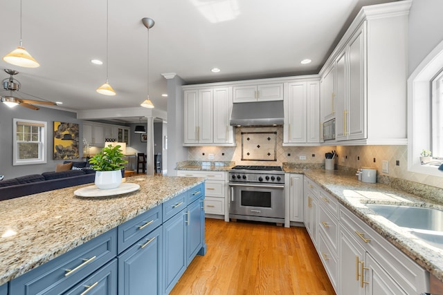 6972 W Imlay St, Chicago, IL 60631 - kitchen featuring appliances with stainless steel finishes, blue cabinets, under cabinet range hood, open floor plan, and recessed lighting