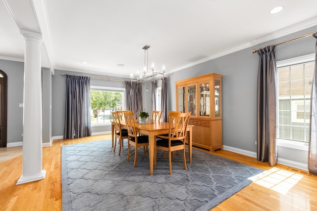 6972 W Imlay St, Chicago, IL 60631 - dining space featuring decorative columns, crown molding, light wood-style flooring, a chandelier, and arched walkways
