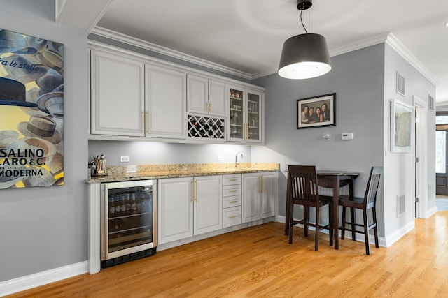 6972 W Imlay St, Chicago, IL 60631 - indoor wet bar featuring beverage cooler, light wood-style floors, ornamental molding, and pendant lighting