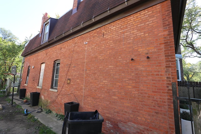 727 N Springfield Ave, Chicago, IL 60624 - view of home's exterior featuring a chimney, brick siding, and mansard roof