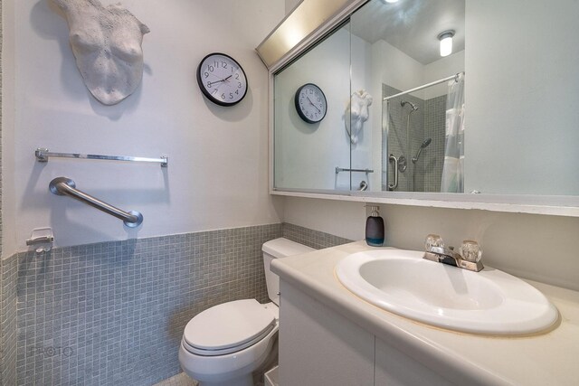 2400 N Lakeview Ave Unit 1706, Chicago, IL 60614 - bathroom with toilet, curtained shower, vanity, tile walls, and wainscoting