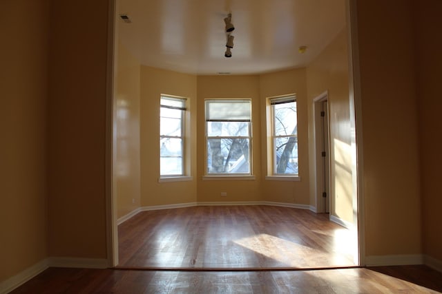 741 N Christiana Ave, Chicago, IL 60624 - unfurnished room with wood finished floors, track lighting, and baseboards