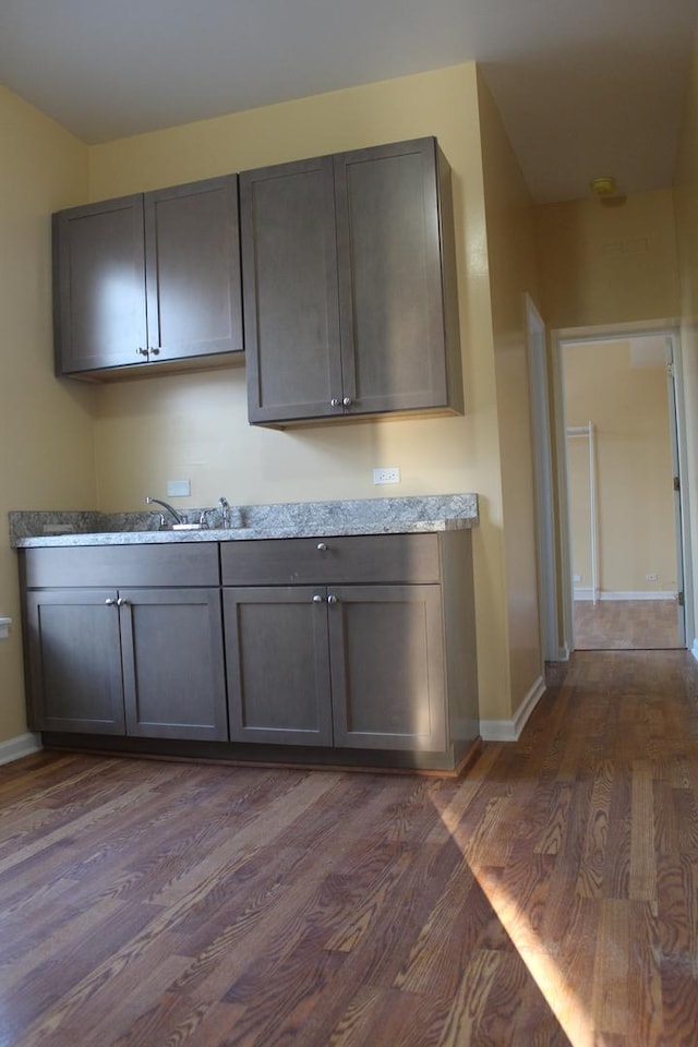 741 N Christiana Ave, Chicago, IL 60624 - kitchen with dark wood finished floors, baseboards, gray cabinets, and light stone counters