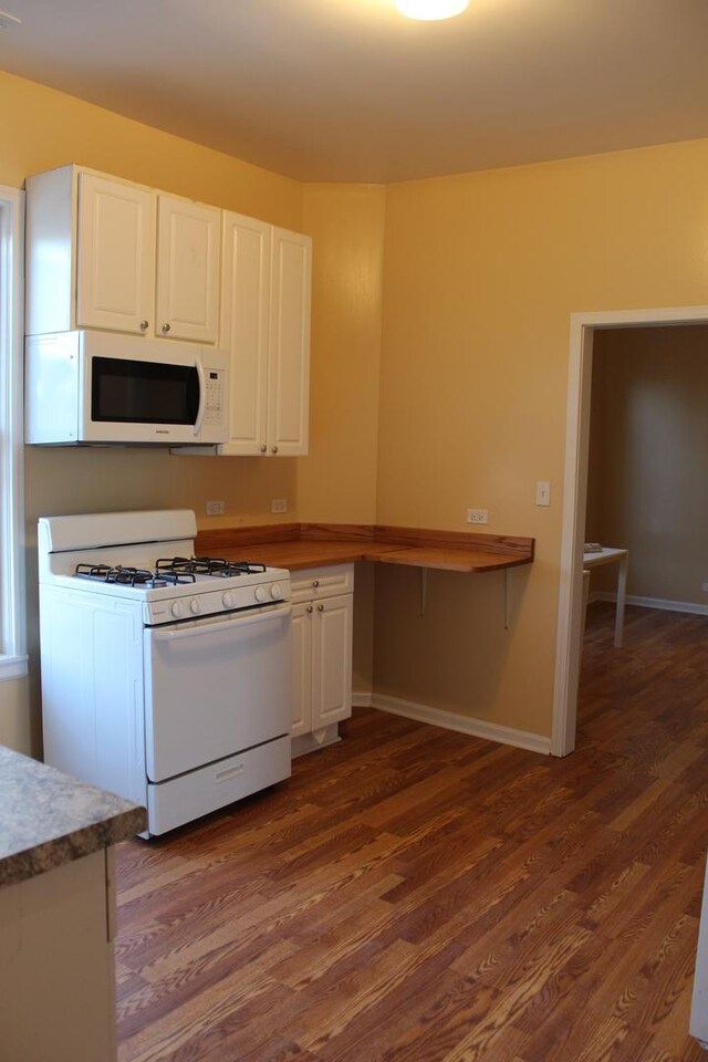741 N Christiana Ave, Chicago, IL 60624 - kitchen with white appliances, dark wood-type flooring, white cabinetry, and baseboards