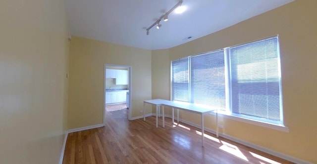 741 N Christiana Ave, Chicago, IL 60624 - unfurnished room with wood finished floors and rail lighting