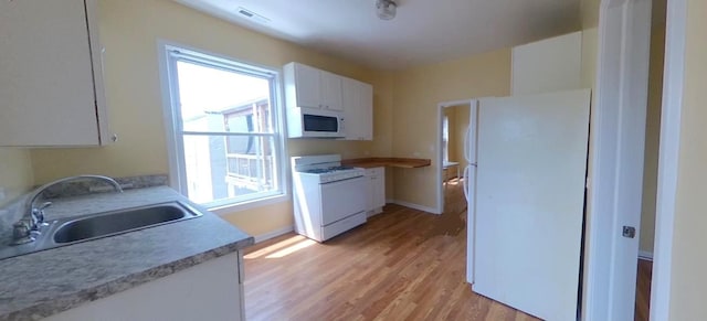 741 N Christiana Ave, Chicago, IL 60624 - kitchen with white appliances, light wood-style flooring, white cabinets, and light countertops