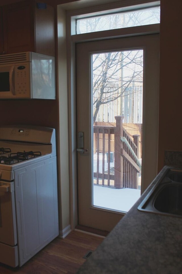 741 N Christiana Ave, Chicago, IL 60624 - kitchen with white appliances, wood finished floors, and baseboards