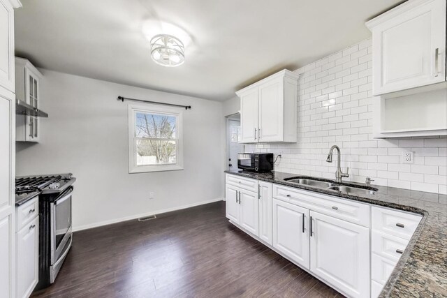 3505 Newcastle Rd, Waukegan, IL 60087 - kitchen featuring stainless steel gas range, a sink, black microwave, decorative backsplash, and dark stone countertops
