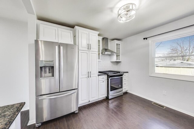 3505 Newcastle Rd, Waukegan, IL 60087 - kitchen featuring appliances with stainless steel finishes, wall chimney range hood, white cabinetry, tasteful backsplash, and glass insert cabinets