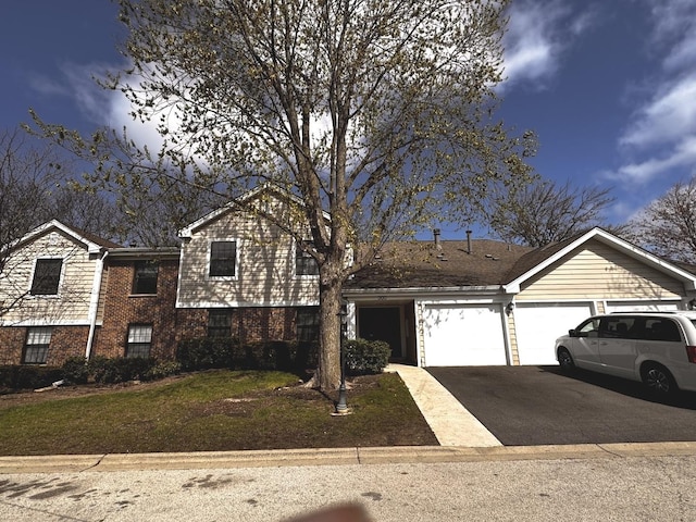 300 Pembridge Ln Unit D2, Schaumburg, IL 60193 - view of front of house with driveway, a garage, brick siding, and a front lawn