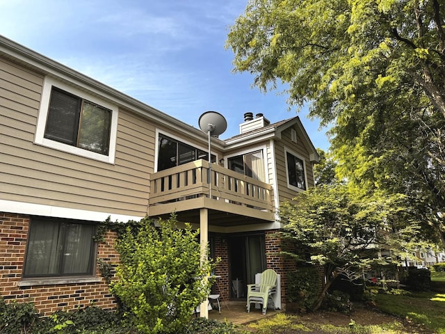 300 Pembridge Ln Unit D2, Schaumburg, IL 60193 - rear view of property featuring a balcony, brick siding, and a chimney